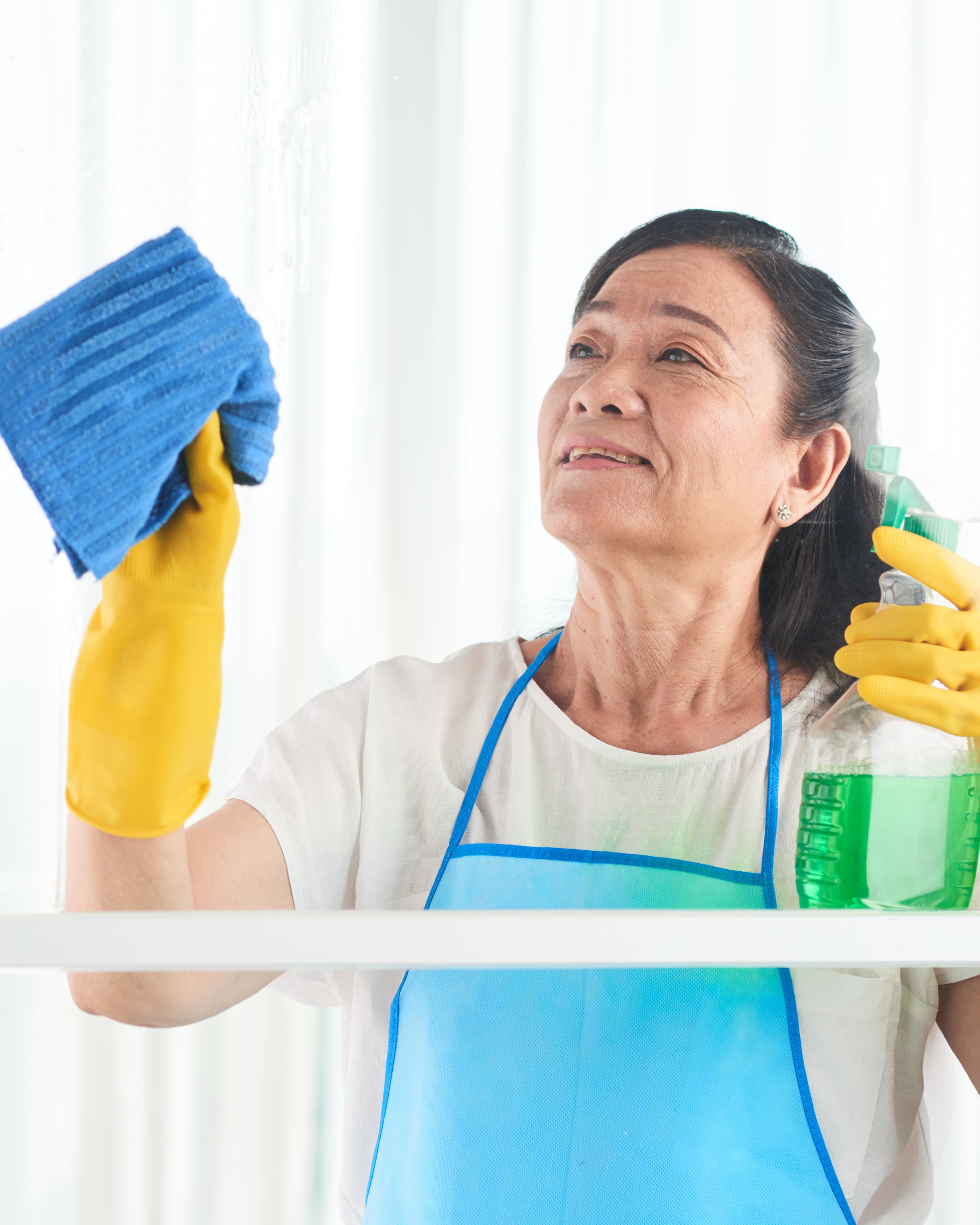 mujer limpiando su vidrios